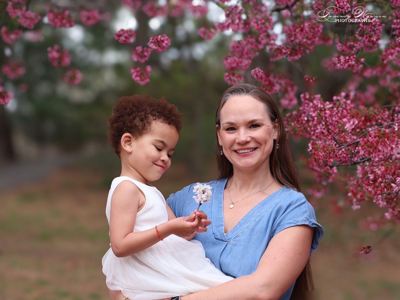 Plate eight: a mother holding her young daughter under a blossoming tree, the child reaching for a flower.