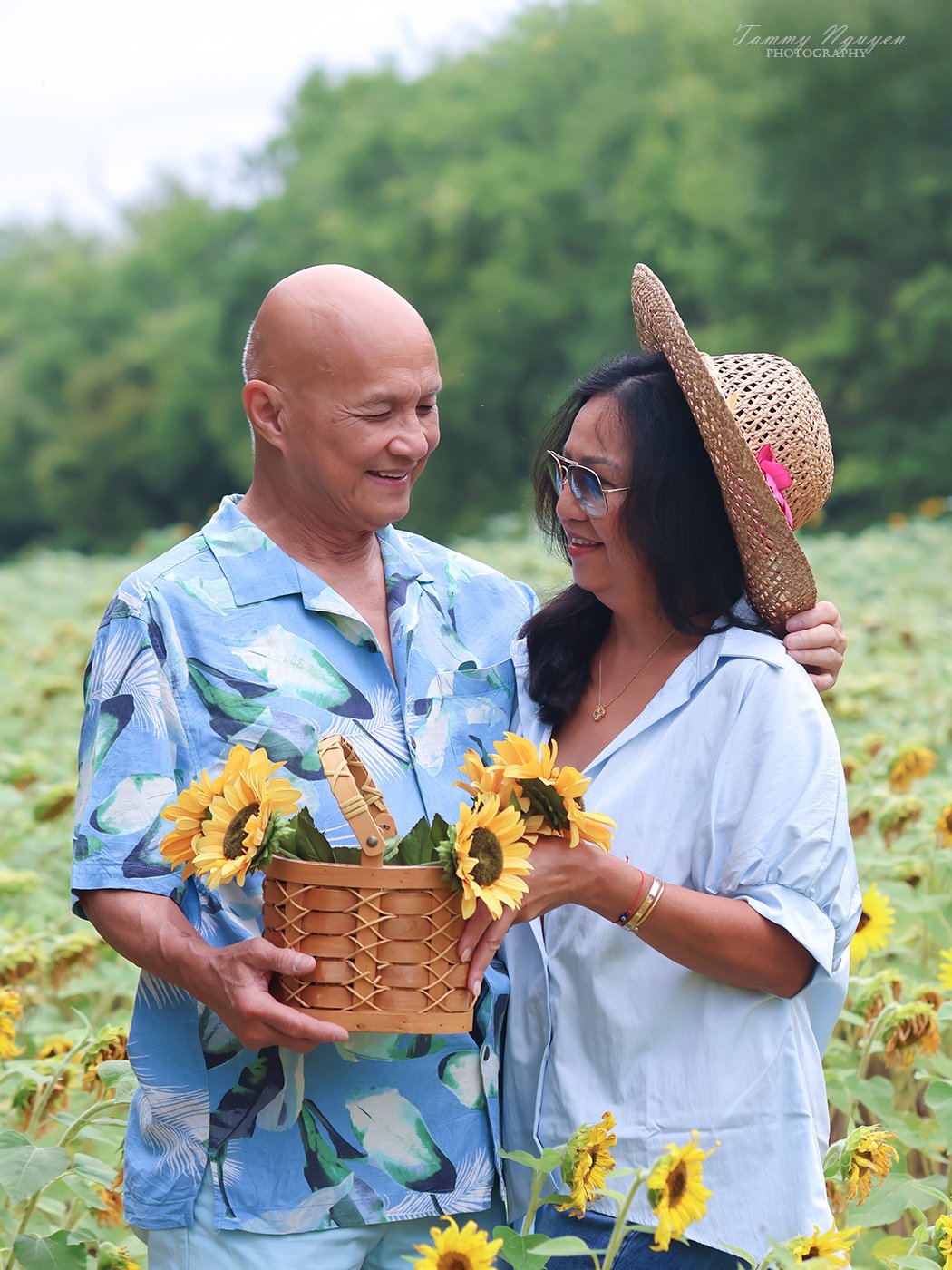 Plate nine: a couple smiling at each other in a sunflower field, holding a basket of sunflowers.